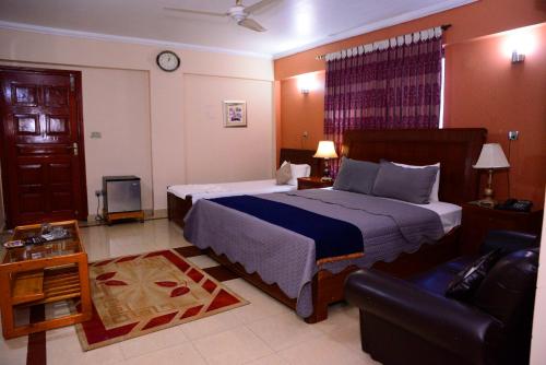 穆扎法拉巴德Mir Continental Hotel & Restaurant的一间卧室配有一张大床和一张沙发