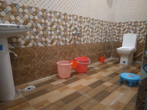 克久拉霍Happy Homestay的浴室设有卫生间和水桶,位于地板上