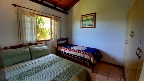 弗洛里亚诺波利斯Casa Vista Panorâmica的一间卧室设有两张床和窗户。