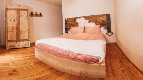平佐洛B&B Maso Ghirola的一间卧室设有一张大床,铺有木地板