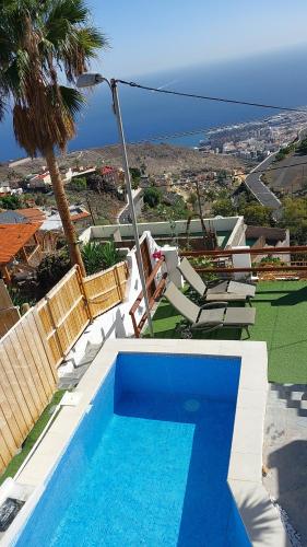 圣克鲁斯-德特内里费Nueva Casa rural piscina privada的一个带椅子的游泳池,享有海景