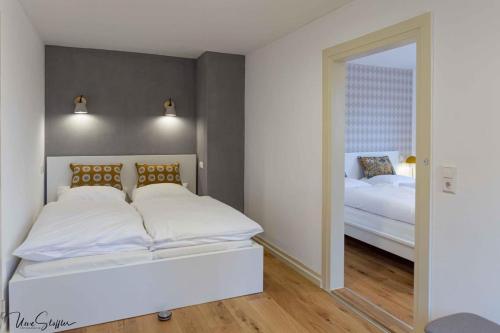 BillingsbachFerienhaus Honey Bee的卧室配有一张白色大床和镜子