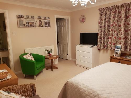 EvertonBarn Court Bed and Breakfast的一间卧室配有一张床、一台电视和一把椅子