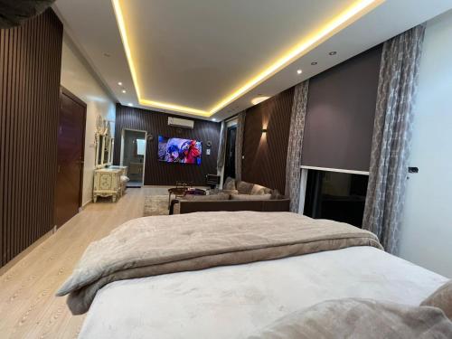 利雅德شقه فاخرة بالنرجس بالقرب من المطار的一间卧室配有一张大床和一台平面电视
