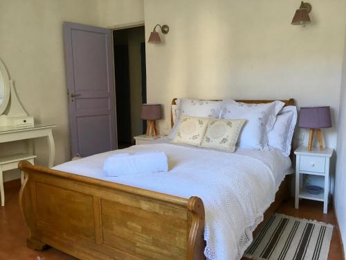 拉格拉斯La maison Vigne Vierge的卧室配有一张带白色床单和枕头的大床。