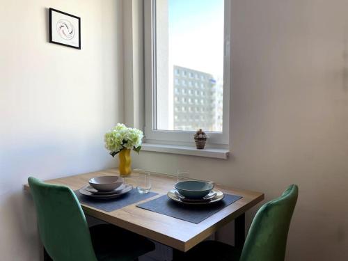 布拉迪斯拉发SkyNest B204的一张带绿椅的餐桌和窗户
