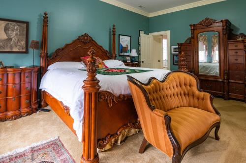 斯普林菲尔德Exquisite Victorian的一间卧室配有一张大床和一把椅子