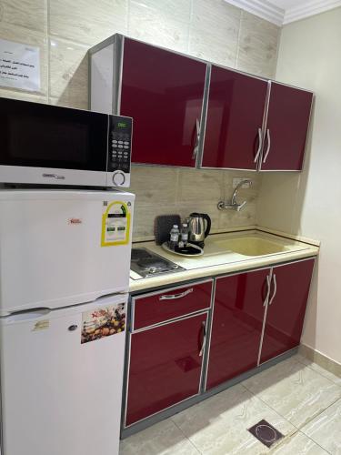 吉达قصر الذهب للوحدات السكنية المخدومة的厨房配有冰箱和微波炉。