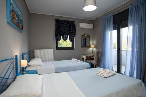 Apidias LakosVilla Aggemari的一间卧室设有两张床和窗户。