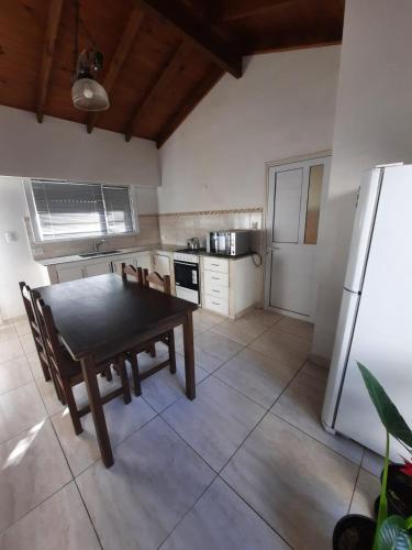 内科切阿Necochea-Casa para hasta 4 personas!的厨房配有餐桌和冰箱