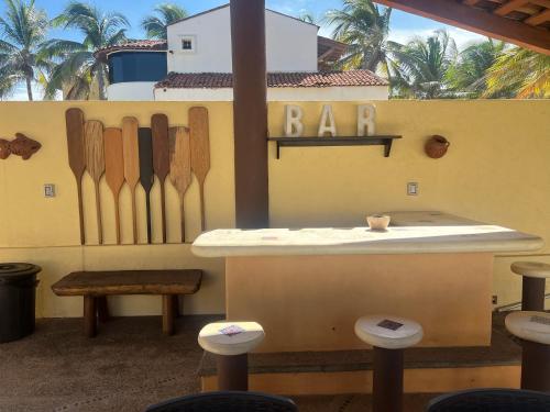 锡瓦塔塔内霍Casa Mana: Beachfront Home w/pool on Playa Blanca的酒吧,墙上有木刀,还有凳子