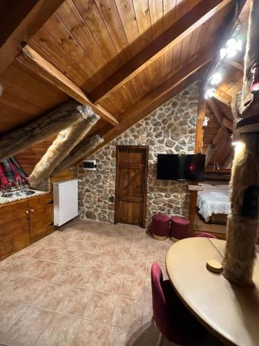 OítiΟ Σκίουρος Παραδοσιακοί Ξενώνες的大型客厅设有木制天花板和桌子