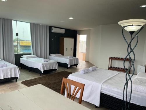 里约布兰科Hostel e Pousada do Bosque的酒店客房设有三张床和一张桌子