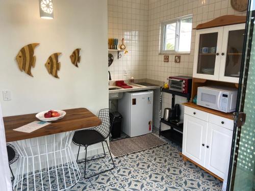 弗洛里亚诺波利斯Residencial Jurerê Belo的一间带桌子和微波炉的小厨房