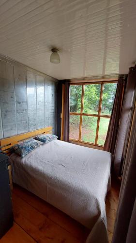 PoásCasa Monte Armadillo的一间卧室设有一张床和一个大窗户