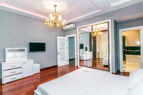 巴库Vip Apartment Zanzibar的卧室配有白色的床和电视。