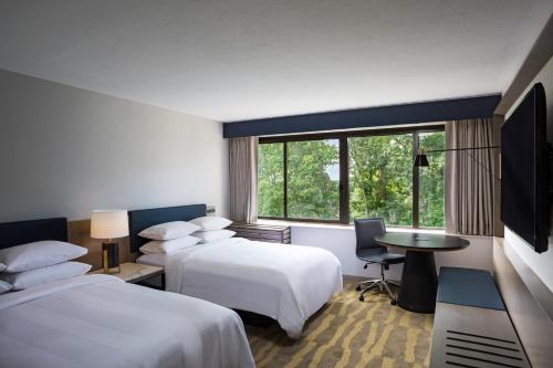 南波特兰Portland Sheraton at Sable Oaks的酒店客房配有两张床和一张书桌