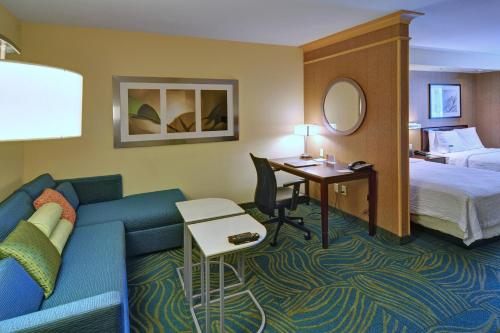 欧文SpringHill Suites by Marriott Dallas DFW Airport East Las Colinas Irving的酒店客房设有沙发、床和书桌