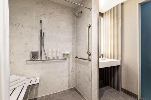 皇后区Marriott New York JFK Airport的带淋浴和盥洗盆的浴室