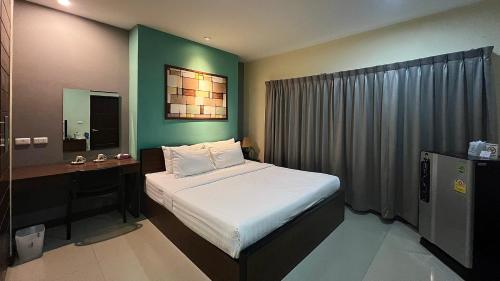 南邦马别致及舒适公寓式酒店的一间卧室配有一张床和一张带镜子的书桌