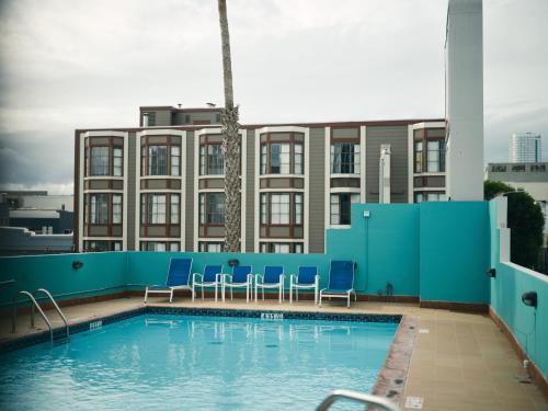 旧金山SoMa House的一座带蓝色椅子的游泳池和一座建筑