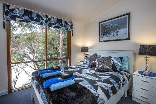 Baw Baw VillageTanjil Creek Lodge的一间卧室设有一张床和一个大窗户