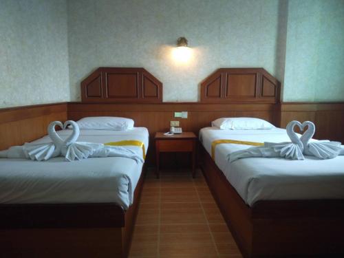 色军萨卡尔大皇宫酒店的两张床铺,位于酒店客房内,配有天鹅