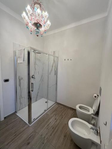 卡莫利La CONCHIGLIA Bed & Breakfast的带淋浴和卫生间的浴室以及吊灯。