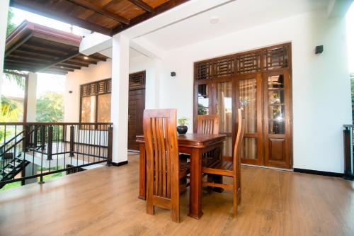 坦加拉Dream Villa - Tangalle的一间带木桌和椅子的用餐室