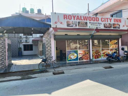 比拉特纳加尔Royalwood City Inn的一间在大楼前停放自行车的餐厅