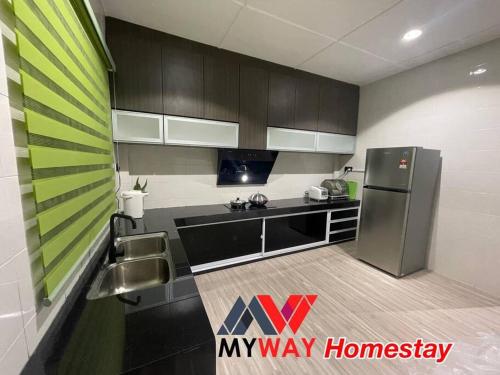 SarikeiMyway Homestay Sarikei的厨房配有不锈钢冰箱和灰色橱柜