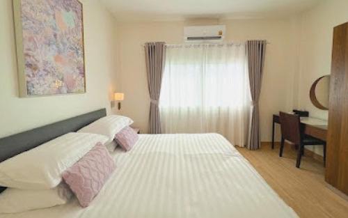 班昌Baan Naya ที่พักสัตหีบ的卧室配有一张白色大床和一张书桌