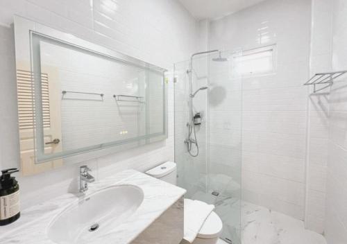 班昌Baan Naya ที่พักสัตหีบ的白色的浴室设有水槽和淋浴。