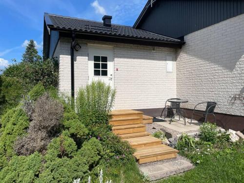 卡尔斯库加Lägenhet med uteplats的一座带木制楼梯的房屋,可通往庭院