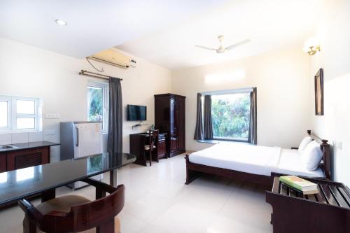 班加罗尔Sanctum Suites Indiranagar Bangalore的一间卧室配有一张床、一张桌子和一张桌子