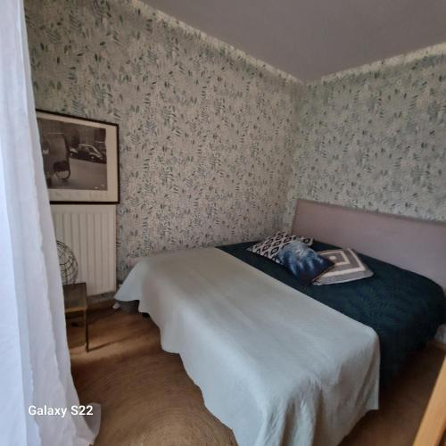 圣旺Saint Ouen Appartement cosy的壁纸客房内的一间卧室配有一张床