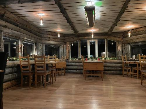 KoskullskulleSkogen-Lodge的餐厅设有木桌、椅子和窗户。