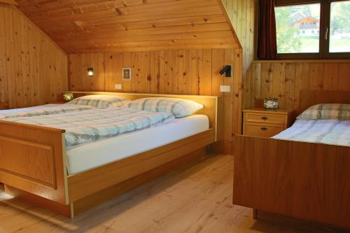 拉维拉Ciasa Alfri的小木屋内一间卧室,配有两张床