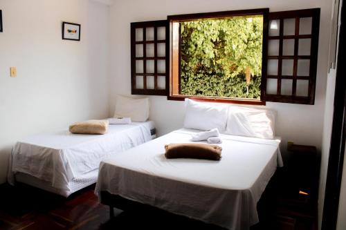 圣洛伦索Pousada dos Ventos São Lourenço的带窗户的客房内的两张床