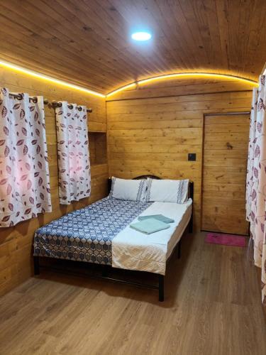 北碧ชายเขาโฮมสเตย์的木制客房内的一间卧室,配有一张床