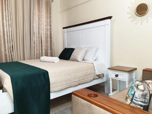 Kitengela Elegant studio stays的一间卧室配有一张带绿毯的床