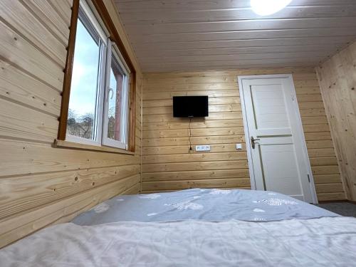 普拉韦Карпатська ніч的木制客房的一间卧室配有一张床,设有窗户