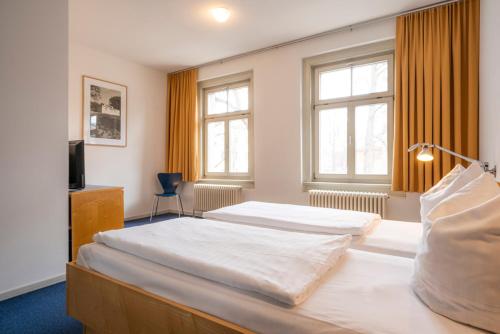 魏玛Hotel Alt-Weimar的酒店客房设有两张床和电视。