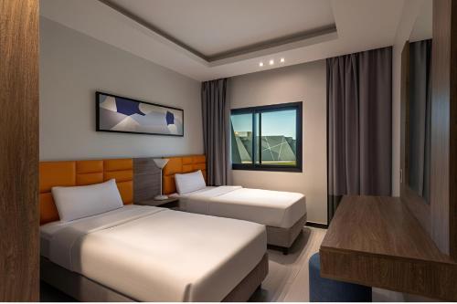 阿可贺巴HDB Al Khobar Resort & Spa的酒店客房配有两张床和一张书桌