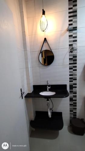 巴拉奈里奥-坎布里乌Quitinete compacta的一间带水槽和镜子的浴室