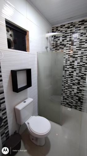 巴拉奈里奥-坎布里乌Quitinete compacta的一间带卫生间和玻璃淋浴间的浴室