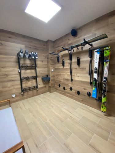 耶塞尼克Apartmány & Wellness Revenite的健身房设有木墙,配有可可可可可的健身器材