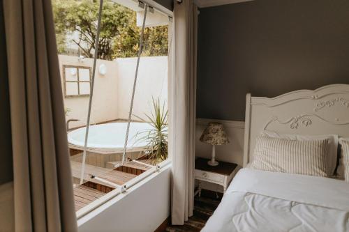 弗洛里亚诺波利斯Pousada Paty´s Garden的一间卧室设有一张床和一个玻璃窗