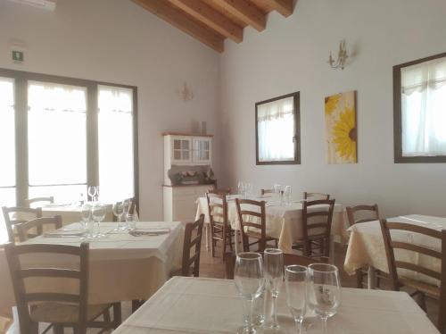 布伦塔河畔皮亚佐拉Agriturismo Honey Farm的用餐室配有桌椅和酒杯
