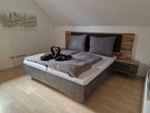 TrattenAparts Lakeview -Gerlitzen -Ossiacher See -Ski的一间卧室配有一张大床和木制床头板